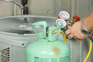 Ocean County air conditioner repair technician with meters near a tank of refrigerant